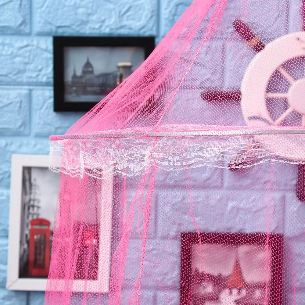 Pink lace dome mosquito net canopy covering a window with framed pictures