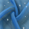 Blue sheer tulle fabric with silver stars is draped and folded
