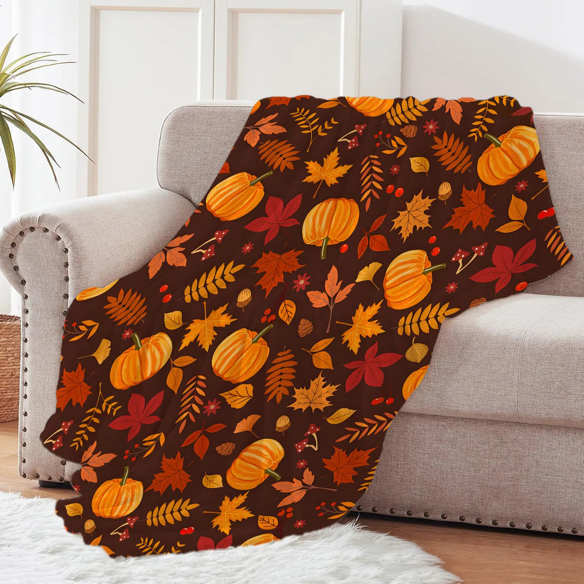 A cozy plush fleece throw blanket featuring an autumn foliage design with orange, yellow, and red leaves on a dark background