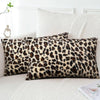 Two leopard print velvet pillow covers resting on a white sofa or bed.