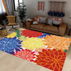 A vibrant outdoor area rug featuring a colorful tropical botanical pattern on a light wooden floor.