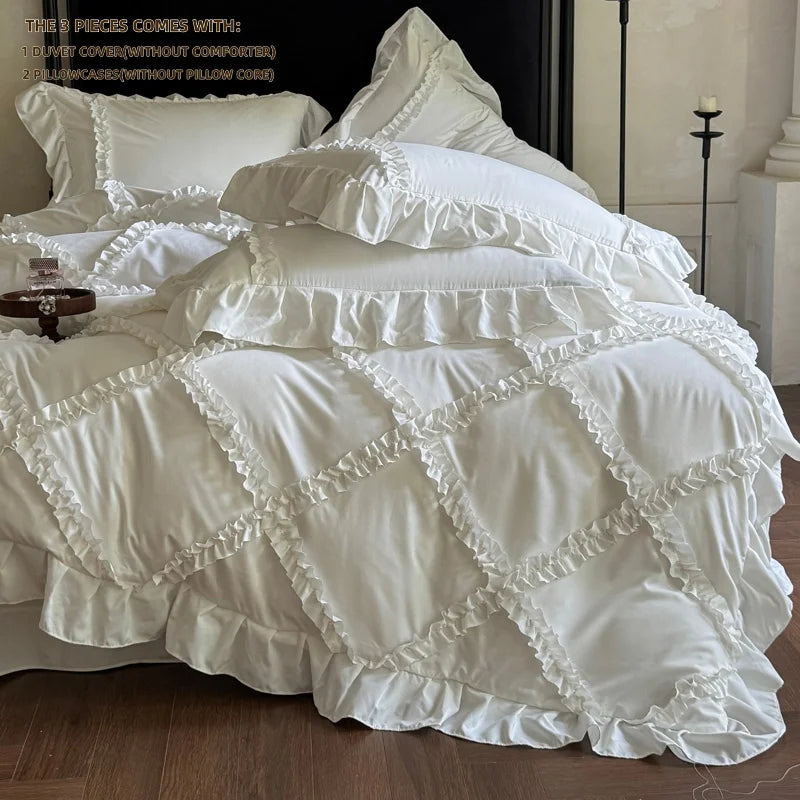 A white ruffled duvet cover set with decorative stitching is displayed on a bed.