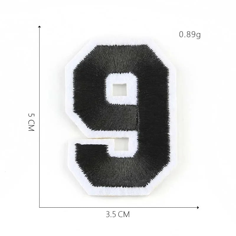 A black felt number 9 patch with white trim and a square cutout, measuring 3.5 cm by 5 cm.