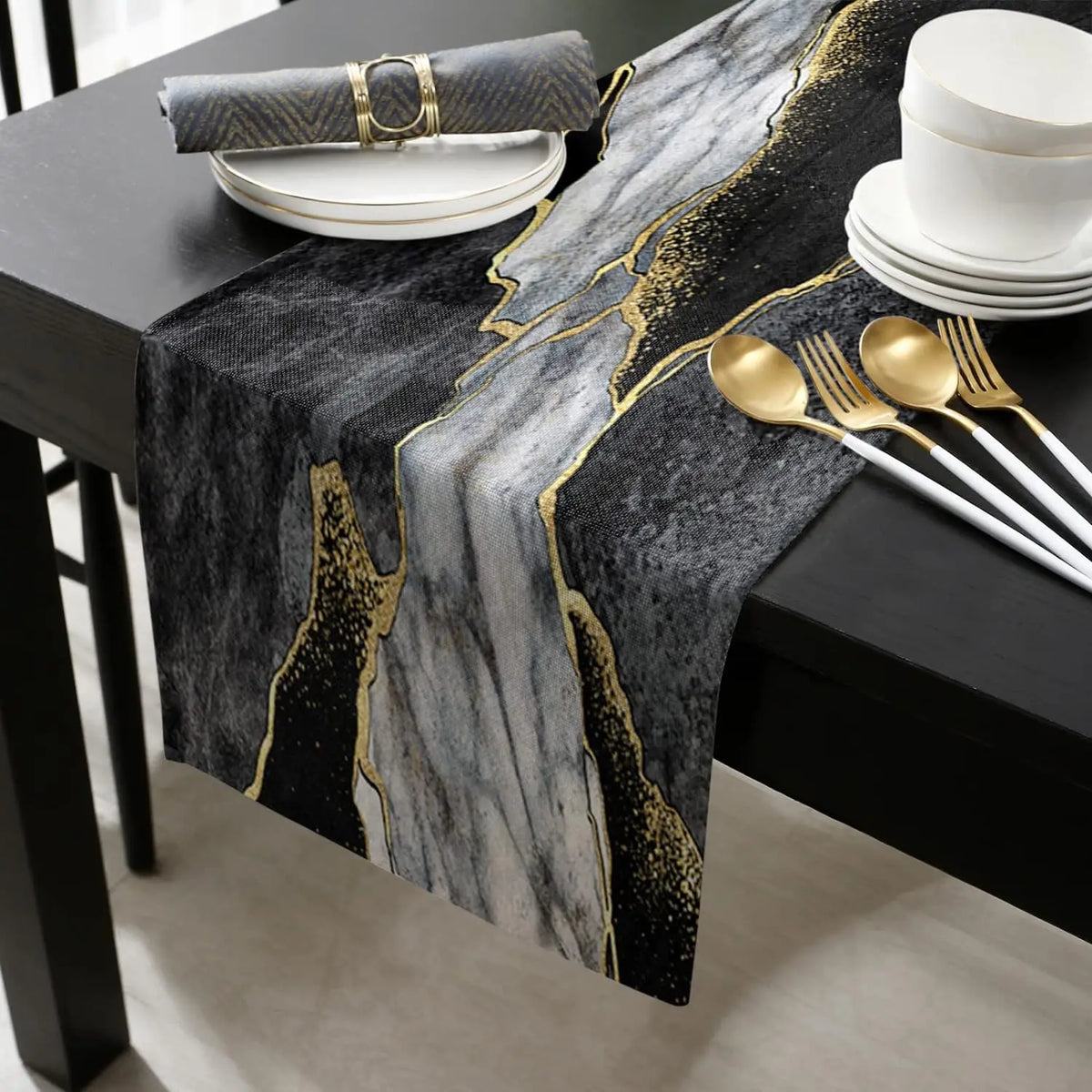 Black and gold abstract marble linen table runner displayed on a dark table with white plates.