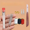 A hand sewing tool kit showing various needles, pins, and thread spools on a palm.