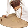 A model wearing a brown cropped top and white shirt, holding a tan foldable tote bag.