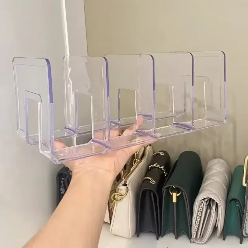A hand holds a clear plastic storage organizer with four sections, displaying various leather wallets and accessories.