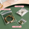 Clear plastic jewelry storage bags with various sizes like 6x8, 8x12, and 4x6 holding gold and pearl rings.