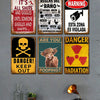 A collection of vintage metal wall art signs featuring humorous and warning messages on a gray wall.