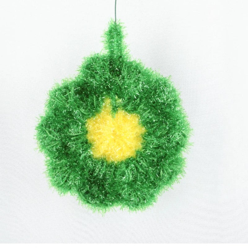 A green sponge with a yellow flower shape is displayed against a white background.