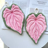 Two pink and green felt heart-shaped plant design hand towels displayed on a magazine page.