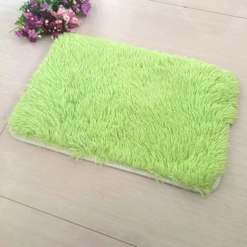 A bright lime green faux fur rug placed on a light wooden floor next to some purple flowers.