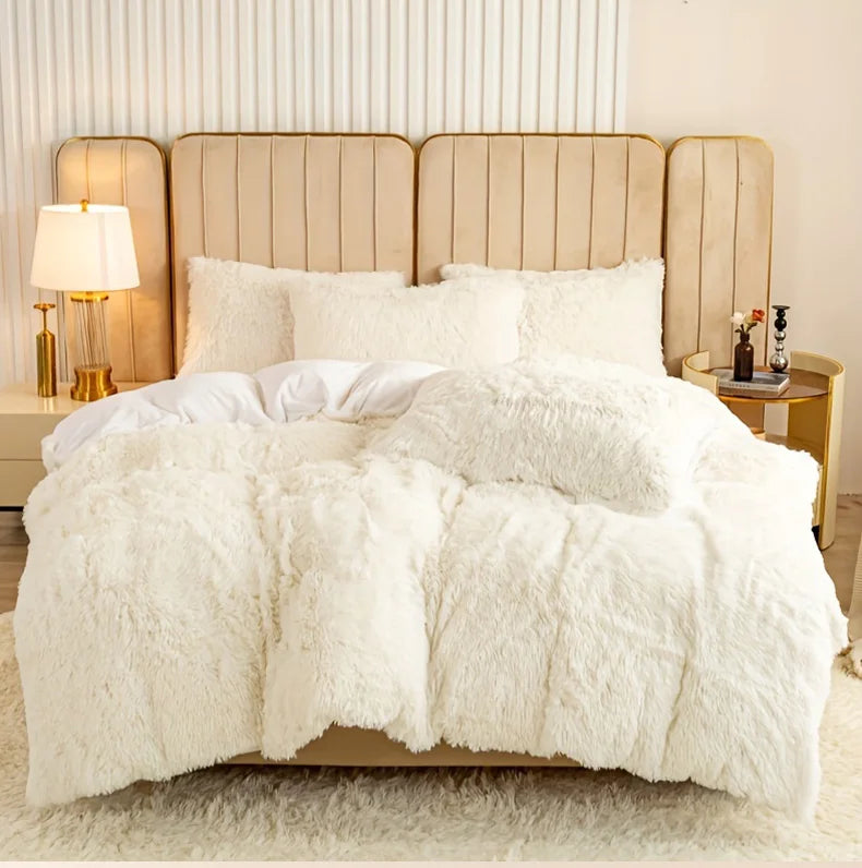 A fluffy white plush duvet cover set displayed on a bed with a neutral upholstered headboard and bedside lamps.