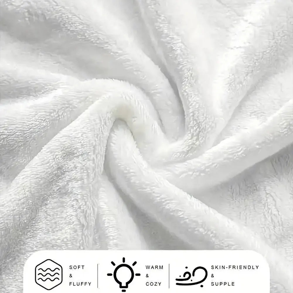 A white, fluffy dinosaur cartoon throw blanket is shown in a soft, draped texture.