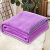 A stack of vibrant purple coral fleece throw blankets resting on a white fluffy surface.