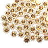 A close-up of sunflower crystal rhinestone sew-on buttons in gold and clear tones.