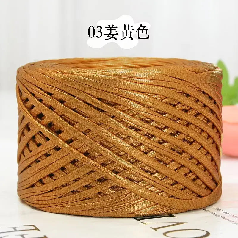 A tightly wound ball of metallic gold cake yarn for crafting.