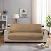 A beige waterproof anti-slip sofa slipcover placed on a light gray floor in a modern living room.