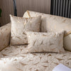 A beige luxury chenille sofa cover featuring geometric patterned pillows on a sofa.