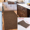 A close-up view of a brown striped runner rug placed on a wooden floor in a modern kitchen setting.
