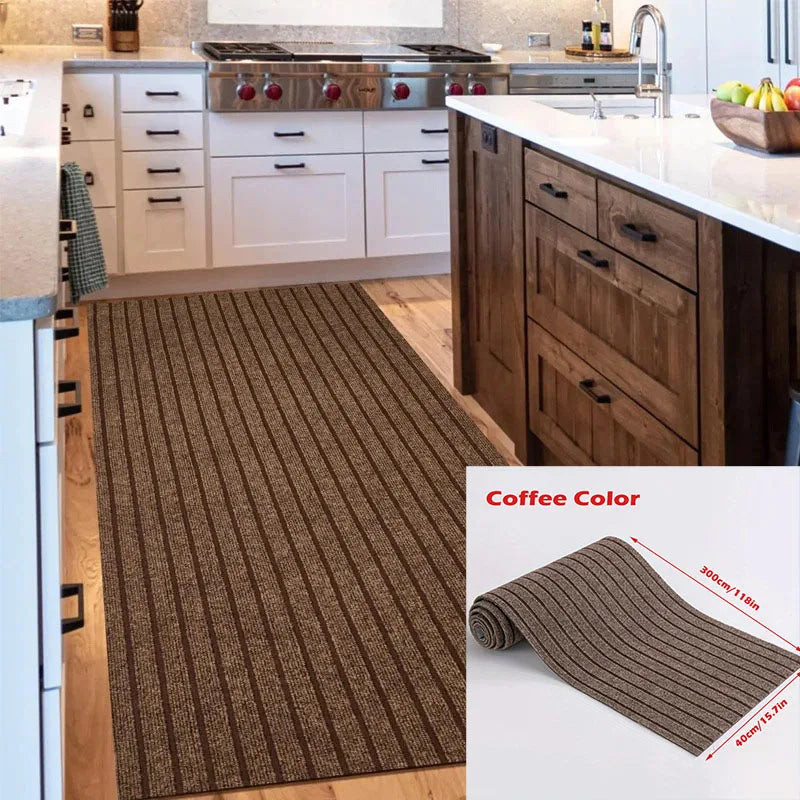 A close-up view of a brown striped runner rug placed on a wooden floor in a modern kitchen setting.