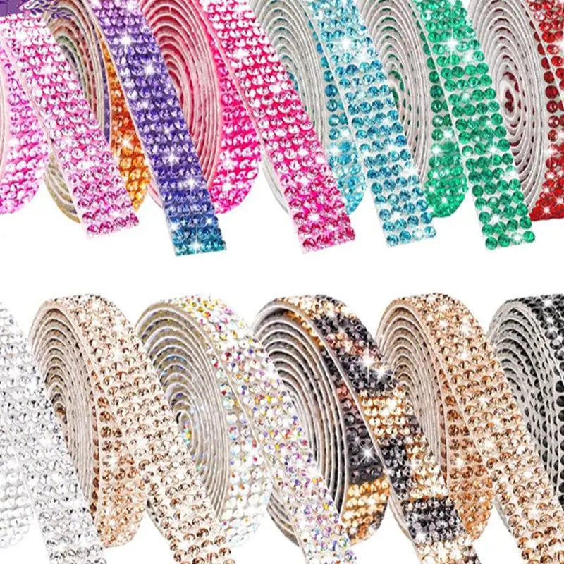A close-up of various crystal rhinestone sticker ribbon rolls in pink, purple, teal, and green colors.