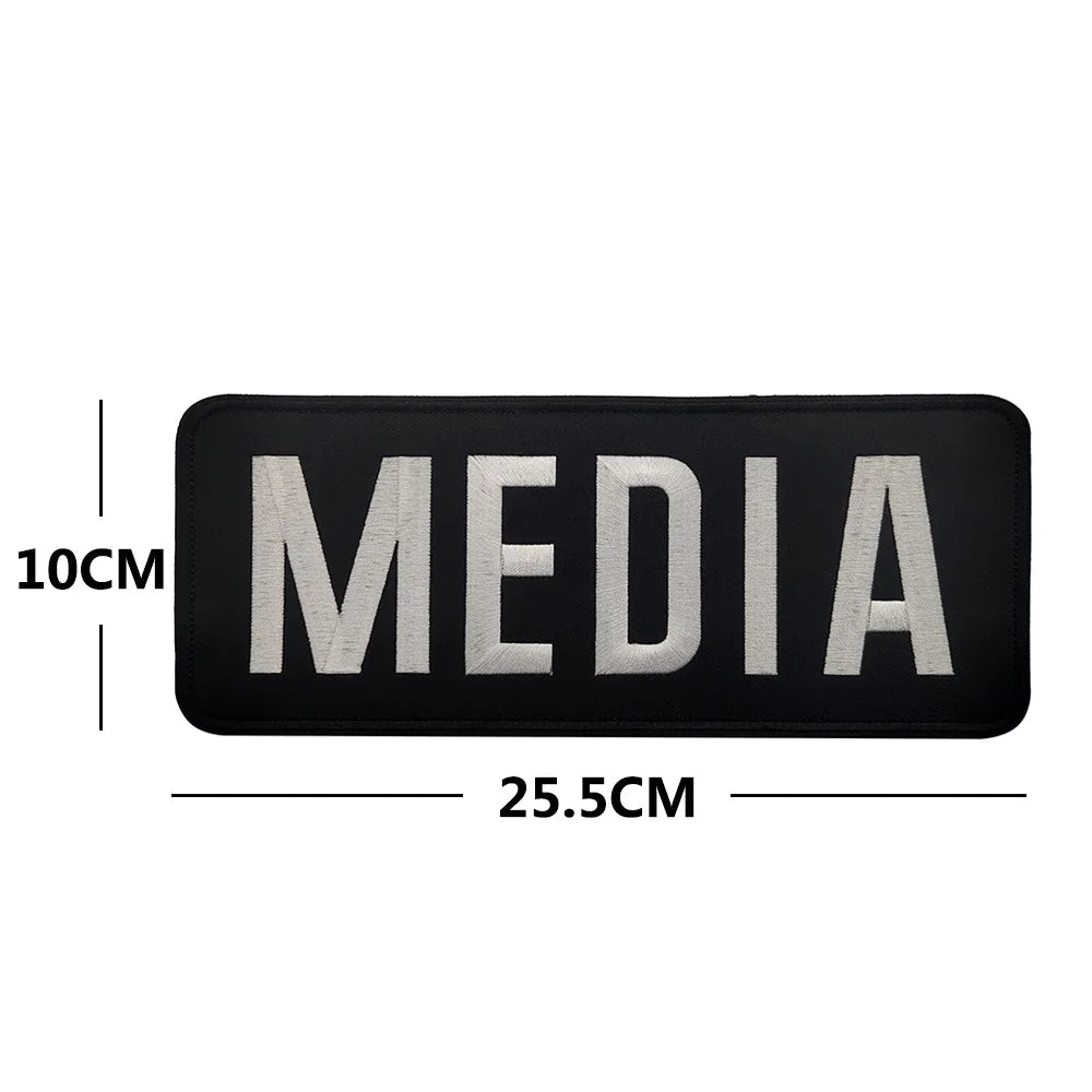 Black media name patch embroidered with silver text and hook and loop backing