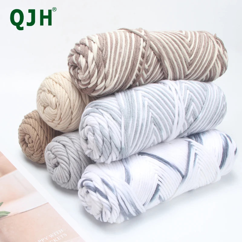 A stack of premium worsted cotton yarn in various shades of beige, gray, and white.