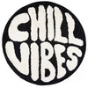 Black and white fuzzy round floor mat with the text CHILL VIBES in a distressed letter pattern