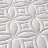 White quilted mattress protector featuring a repeating geometric pattern.
