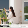 A woman is tending to plants near a window featuring one-way privacy film that blocks UV rays and heat.