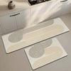 A rectangular beige and white non-slip kitchen floor mat with concentric line patterns is displayed on a light gray counterto