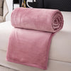A folded pink flannel throw blanket resting on a white sofa.
