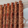 Close-up of reddish-brown tree bark pattern blackout curtains hanging on a white rod.