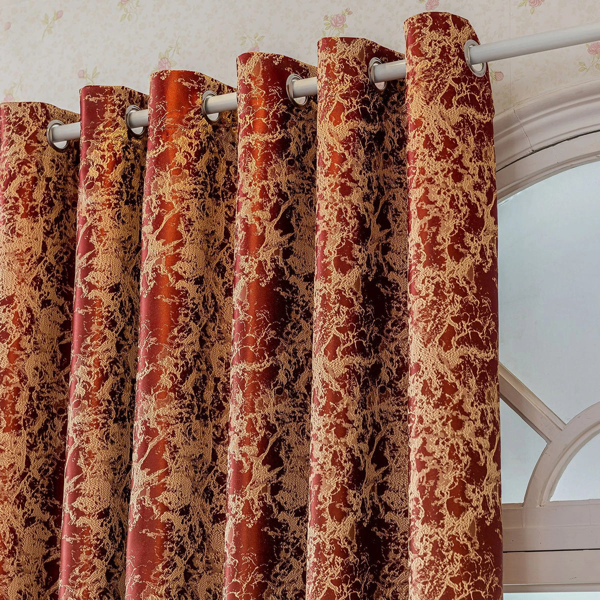 Close-up of reddish-brown tree bark pattern blackout curtains hanging on a white rod.