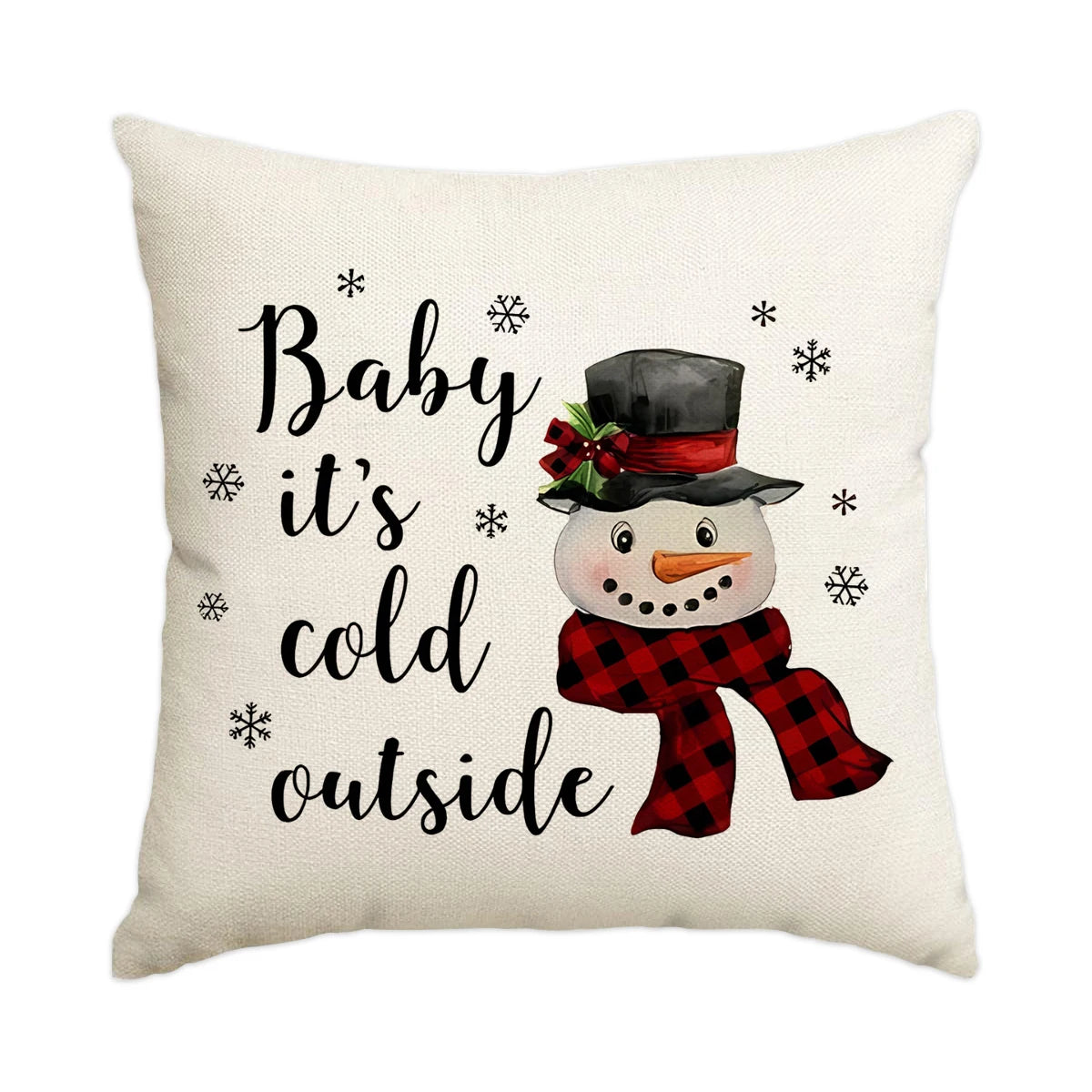 A cream-colored pillow featuring text that reads Baby it's cold outside and a graphic of a snowman wearing a hat and scarf.