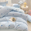 A light blue duvet cover set with pink bowknot embroidery and a matching pillow core displayed on a bed.