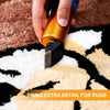 A hand holds an orange cordless carpet trimmer, applying detail work to a textured rug.