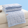 Light blue plaid quilted duvet cover folded on a white surface.