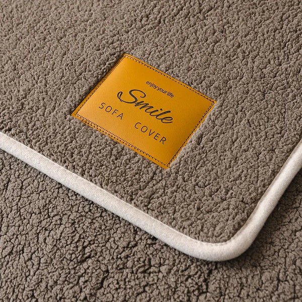 A yellow tag labeled Smile Sofa Cover is placed on a gray fleece mat.