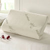 A white contoured memory foam pillow with a breathable bamboo cover featuring bamboo leaf patterns.