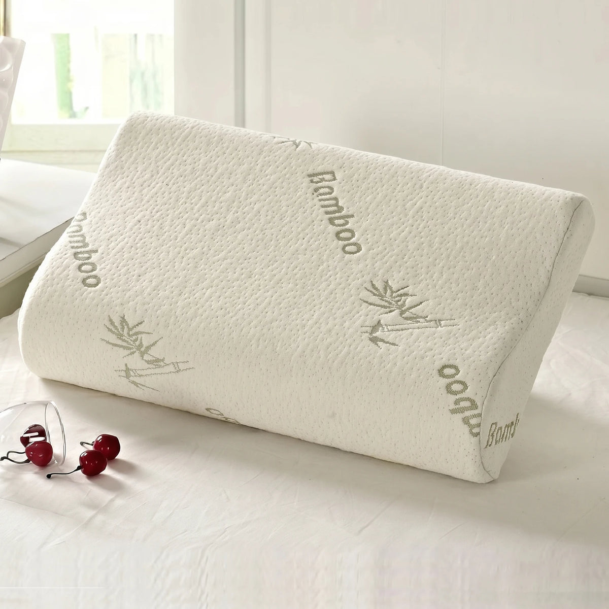 A white contoured memory foam pillow with a breathable bamboo cover featuring bamboo leaf patterns.
