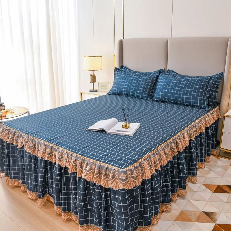 A navy blue plaid bed skirt with a lace trim is displayed on a bed, next to a light-colored headboard.