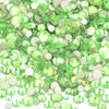 A pile of clear green and silver glass rhinestones for DIY crafts.