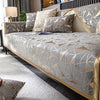 A luxury chenille sofa cover featuring geometric patterns in gray and gold tones on a modern sofa.