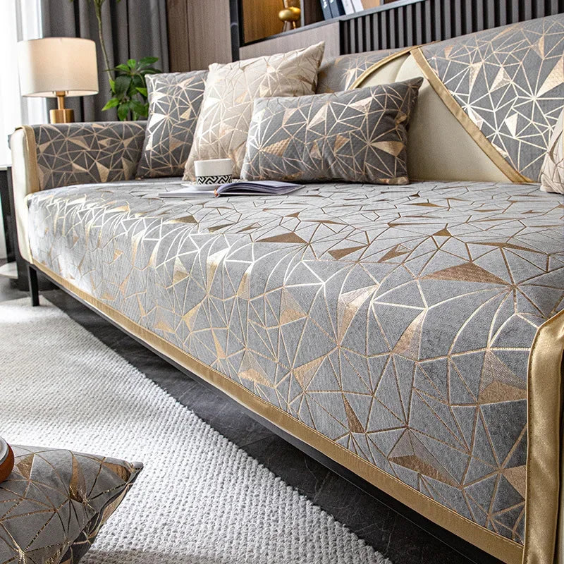 A luxury chenille sofa cover featuring geometric patterns in gray and gold tones on a modern sofa.