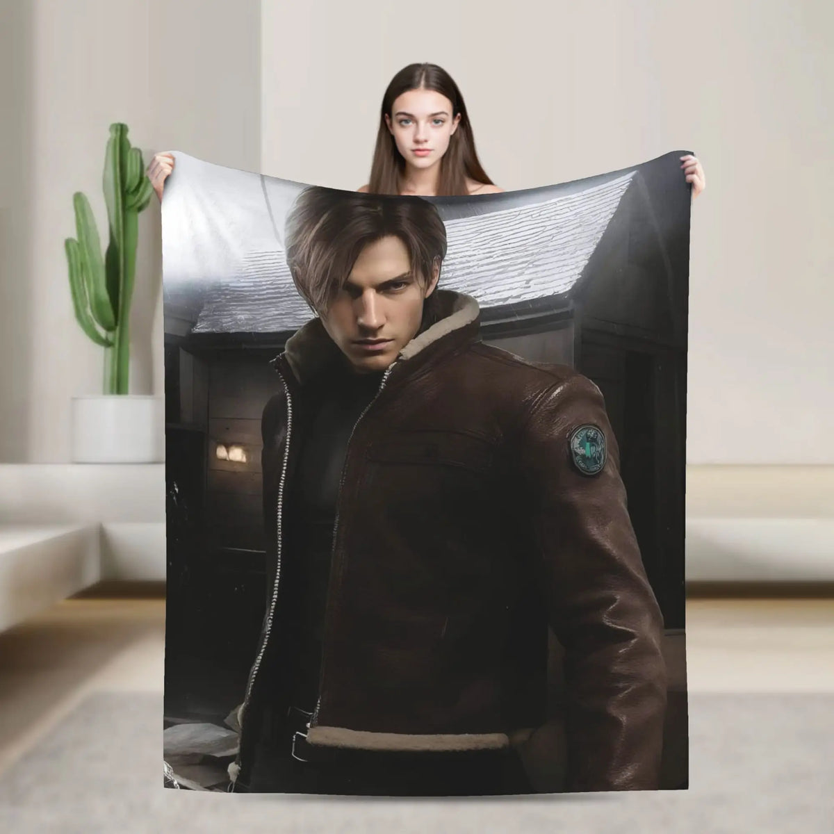 A person holds up a large graphic throw blanket featuring a portrait of a man in a leather jacket.
