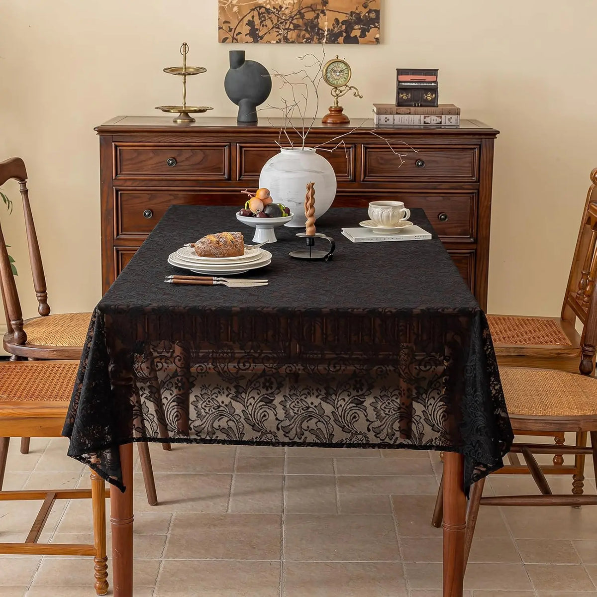 Elegant black lace tablecloth with floral embroidery set on a wooden dining table.