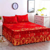 A vibrant red fitted bed sheet set with elastic lace trim displayed on a bed.