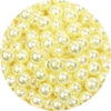 A close-up view of small, round imitation pearl beads in a pale yellow color.